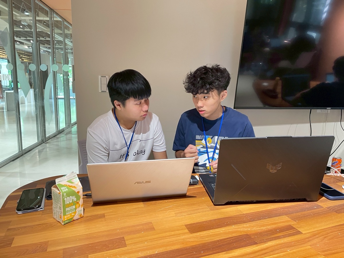 去年競賽:兩位學員在筆電前討論程式